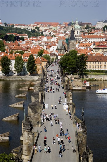 CZECH REPUBLIC, Bohemia, Prague, People walking across the Charles Bridge across the Vltava River towards the Little Quarter