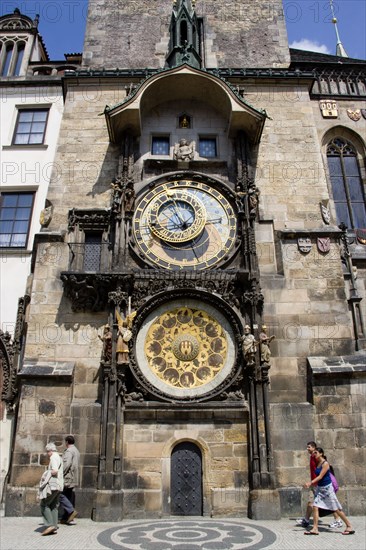 CZECH REPUBLIC, Bohemia, Prague, Old Town. People walking past the Astronomical clock on the tower of The Old Town Hall