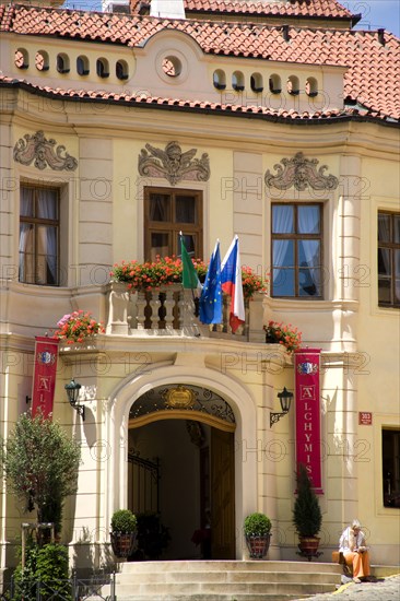 CZECH REPUBLIC, Bohemia, Prague, Woman sitting on the steps up to the Residence Hotel de Charme in the Little Quarter