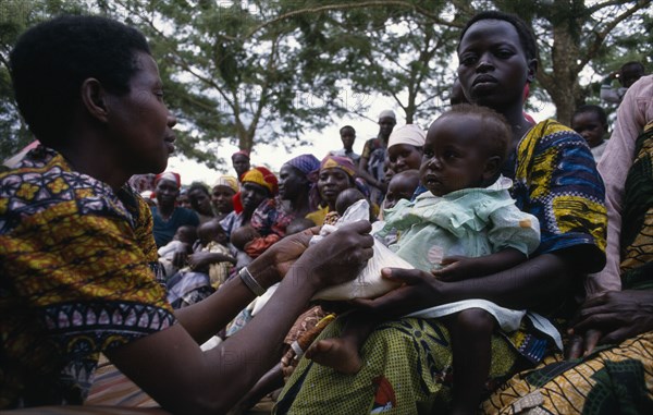 UGANDA, Medical, Health worker giving nutritional advice to mothers with vulnerable babies during food distribution at Orukinga refugee camp near the Rwandan border.