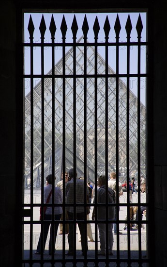 FRANCE, Ile de France, Paris, Tourists outside the pyramid entrance to the Musee du Louvre