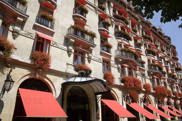 FRANCE, Ile de France, Paris, The facade of the five star Hotel Plaza Athenee on the Avenue Montagne in the heart of the haute couture fashion district with red geraniums in window boxes and red awnings