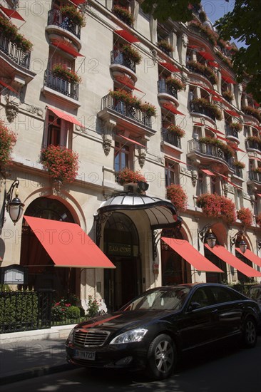 FRANCE, Ile de France, Paris, The facade of the five star Hotel Plaza Athenee on the Avenue Montagne in the heart of the haute couture fashion district with red geraniums in window boxes and red awnings