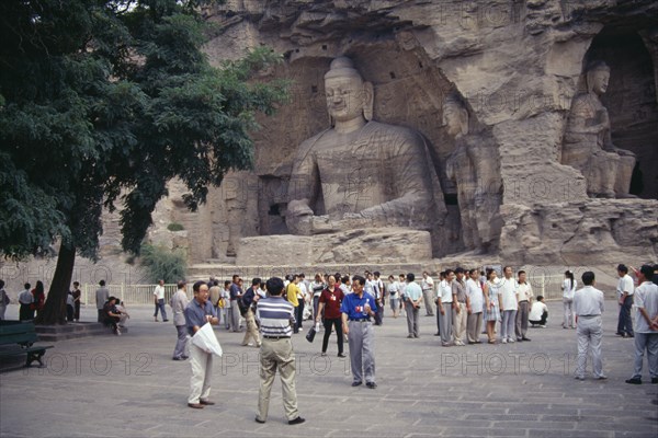 CHINA, Shanxi, Datong, Yungang Caves.  Chinese visitors at ancient Buddhist site with rock carvings dating from AD 386 - 534.