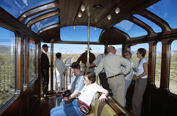 PERU, Transport, Passengers relaxing in observation carriage of Puno to Cusco Perurail train journey.