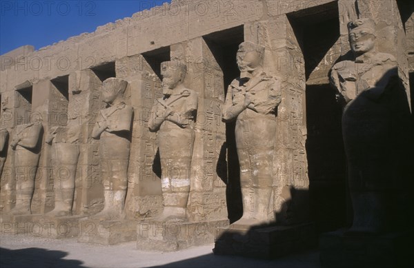 EGYPT, Nile Valley, Karnak, Temple of Amun. Osiride Pillars. Statues with crossed arms bearing the crook and flail