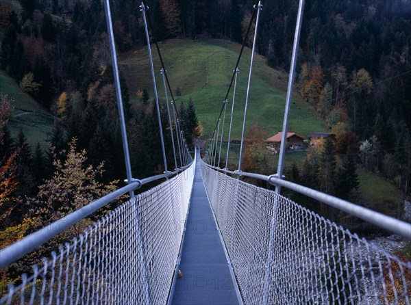 SWITZERLAND, Bernese Oberland, Engstligental , South of Lake Thunersee. Suspension footbridge over River Engstlige which measures 150 metres long stands 30 metres ( 98 feet ) above the river