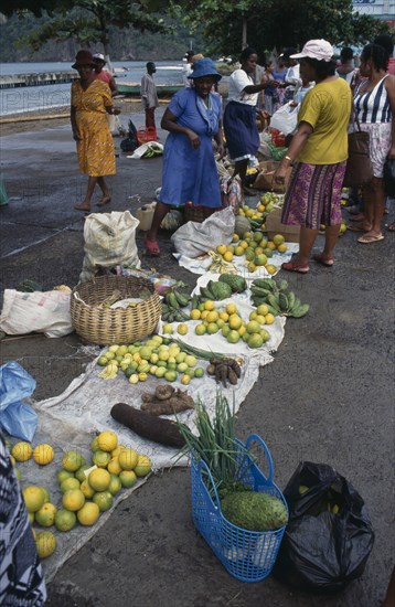 ST LUCIA, Soufriere, "Fruit and vegetable vendors and customers at roadside market.  Yams, oranges, soursop and limes amongst produce for sale."