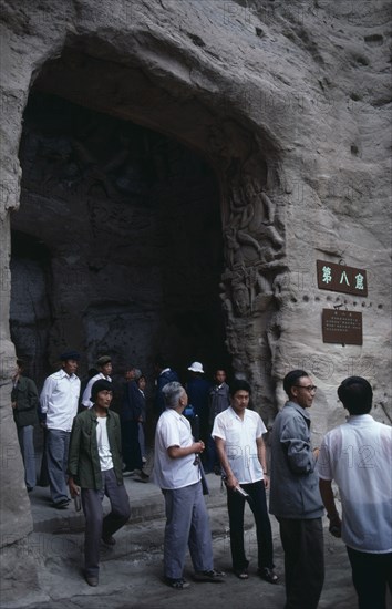CHINA, Shanxi, Datong, Yungang Caves.  Chinese visitors at cave entrance in ancient Buddhist site containing carvings dating from AD 386 - 534.