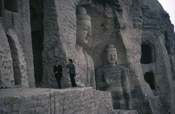 CHINA, Shanxi, Datong, Yungang Caves.  Chinese visitors at ancient Buddhist site with carvings dating from AD 386 - 534.