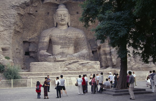 CHINA, Shanxi, Datong, Yungang Caves.  Chinese visitors at ancient Buddhist site with rock carvings dating from AD 386 - 534.