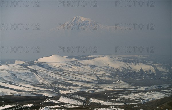 ARMENIA, Mount Ararat, "Aerial view over peaks of Mount Ararat from Voghaberd with Yerevan on the right, note air pollution.  Twin peaked mountain resulting from volcanic activity."