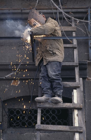 ARMENIA, Yerevan, Welder working on new shop front.