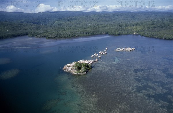 PACIFIC ISLANDS, Melanesia, Solomon Islands, "Malaita Province, Lau Lagoon, Foueda Island.  Aerial view over artificial man made island and houses with mainland covered by dense forest beyond. "