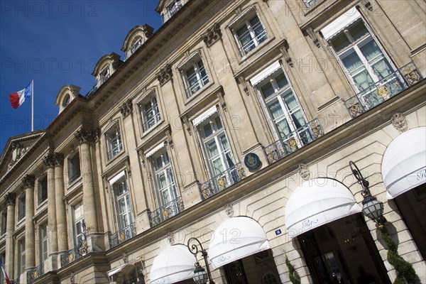 FRANCE, Ile de France, Paris, The Ritz Hotel in Place Vendome with the French Tricolour flying from a flagpole above the Ministry of Justice next door