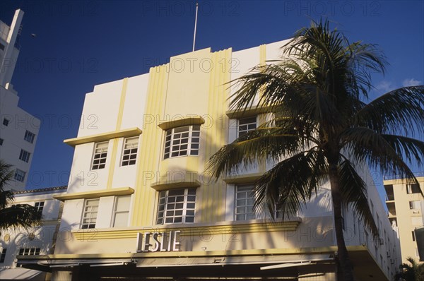 USA, Florida, Miami, South Beach. Ocean Drive. The Leslie Hotel seen in early morning light with a palm tree casting a shadow on the exterior