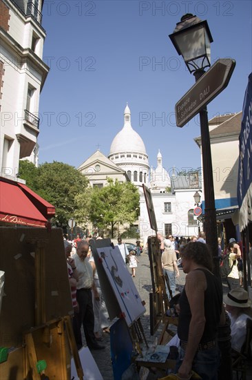 FRANCE, Ile de France, Paris, Montmartre Tourists walking past artists painting in Place du Tertre square beside the Church of Sacre Couer