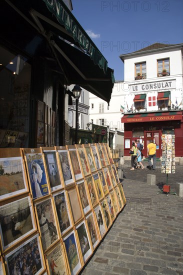 FRANCE, Ile de France, Paris, Montmartre Tourists walking past a shop selling prints of Impressionist paintings and posters beside Le Consulat Restaurant