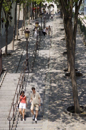 FRANCE, Ile de France, Paris, Montmartre People on the tree lined steps of the Rue Foyatier beside the Funiculaire cable car leading to the Church of Sacre Couer