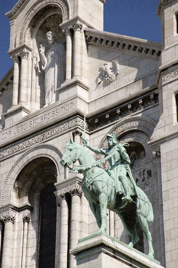 FRANCE, Ile de France, Paris, Montmartre The facade of the church of Sacre Couer with the bronze equestrian statue of Joan of Arc by H Levebure