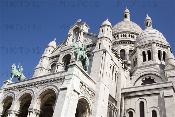 FRANCE, Ile de France, Paris, Montmartre The facade of the church of Sacre Couer with the bronze equestrian statues of Saint Louis and Joan of Arc by H Levebure