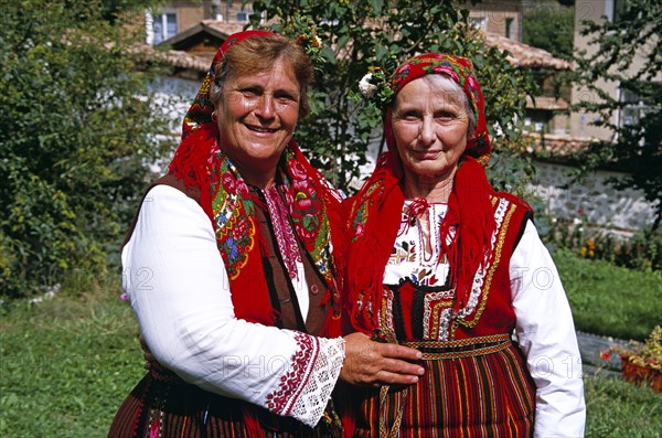 BULGARIA, Dobarsko, "Member of Dobarski Babi Folk Group, and tourist on right, in national costume"