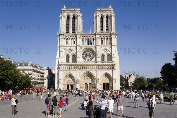 FRANCE, Ile de France, Paris, Tourists in the Place du Parvis Notre Dame in front of the west front of the Gothic Cathedral of Notre Dame on the Ile de la Cite