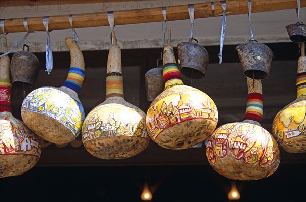 BULGARIA, Melnik., Colourful gourds and cattle bells hanging outside shop.