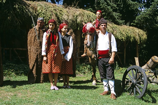 BULGARIA, Pirin Mountain, Chalin Valog, Girls dressed in Bulgarian national costume and men dressed as hunters.
