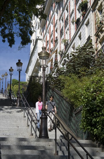 FRANCE, Ile de France, Paris, Montmartre Tourists walking down steps from the church of Sacre Couer leading to Rue Paul Albert