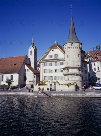 SWITZERLAND, Lucerne Central, Lucerne, Waterfront buildings on north bank of  River Reuss. St Peterkapelle on the left