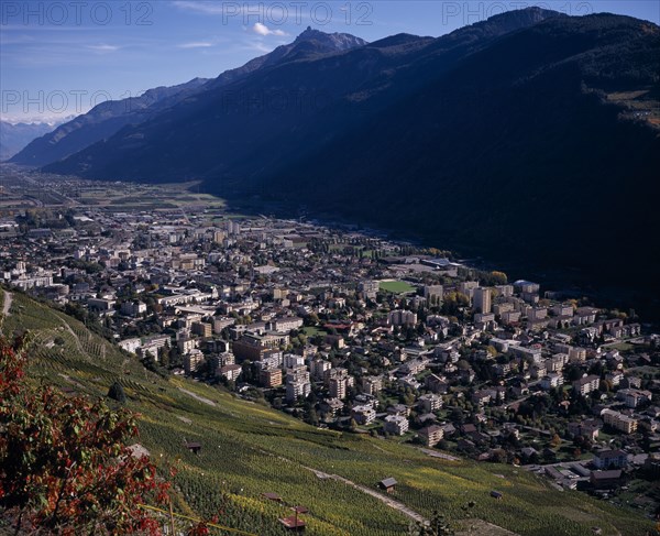 SWITZERLAND, Valais, Martigny, Elevated view east along Rhone Valley above Vineyards and town