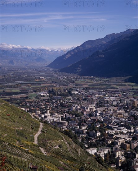 SWITZERLAND, Valais, Martigny, Elevated view east along Rhone Valley above Vineyards and town
