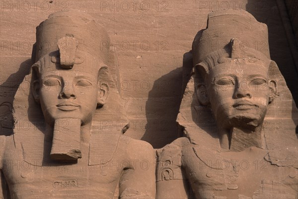 EGYPT, Nile Valley, Abu Simbel, Ramses II enthroned colossal statues. Detail of heads and upper torso.