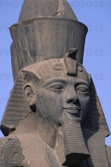 EGYPT, Nile Valley, Luxor, Luxor Temple. Ramses II seated statue with detail of head
