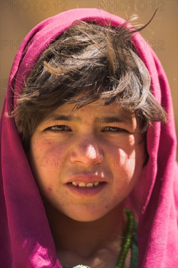 AFGHANISTAN, Bamiyan Province, Bamiyan , Girl that lives in a cave in the cliffs near empty niche where the famous carved small Budda once stood 180 foot high before being destroyed by the Taliban in 2001