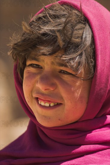 AFGHANISTAN, Bamiyan Province, Bamiyan , Girl that lives in a cave in the cliffs near empty niche where the famous carved small Budda once stood 180 foot high before being destroyed by the Taliban in 2001