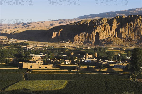 AFGHANISTAN, Bamiyan Province, Bamiyan , View of Bamiyan valley and village showing cliffs with empty niche where the famous carved Budda once stood (destroyed by the Taliban in 2001)