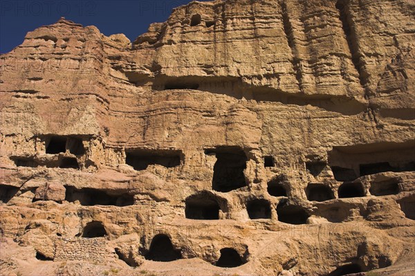 AFGHANISTAN, Bamiyan Province, Bamiyan , Caves in cliffs near empty niche where the famous carved small Budda once stood 180 foot high before being destroyed by the Taliban in 2001 Jane Sweeney