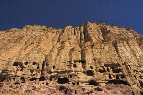 AFGHANISTAN, Bamiyan Province, Bamiyan , Caves in cliffs near empty niche where the famous carved small Budda once stood 180 foot high before being destroyed by the Taliban in 2001