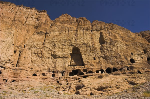 AFGHANISTAN, Bamiyan Province, Bamiyan , Caves in cliffs near empty niche where the famous carved small Budda once stood 180 foot high before being destroyed by the Taliban in 2001