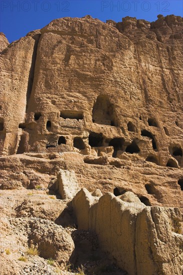 AFGHANISTAN, Bamiyan Province, Bamiyan , Caves in cliffs near empty niche where the famous carved small Budda once stood 180 foot high before being destroyed by the Taliban in 2001