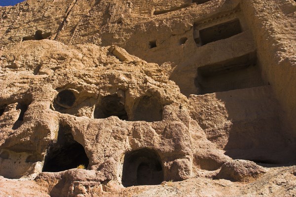 AFGHANISTAN, Bamiyan Province, Bamiyan , Caves in cliffs near empty niche where the famous carved small Budda once stood 180 foot high before being destroyed by the Taliban in 200