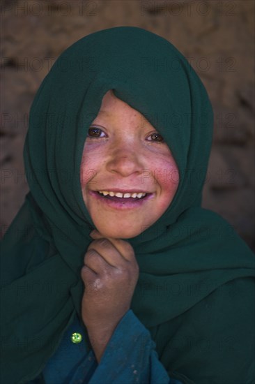 AFGHANISTAN, Bamiyan Province, Bamiyan , Girl that lives in a cave in the cliffs near empty niche where the famous carved small Budda once stood 180 foot high before being destroyed by the Taliban in 2001