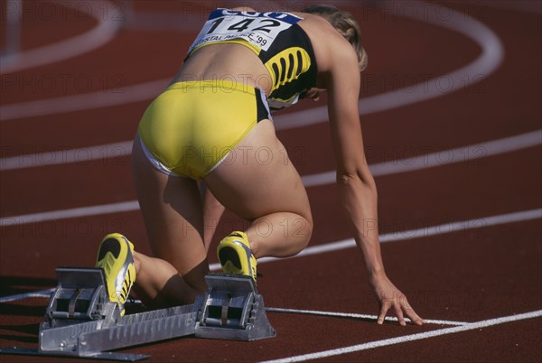 20085196 SPORT Athletics Running Female runner at starting blocks