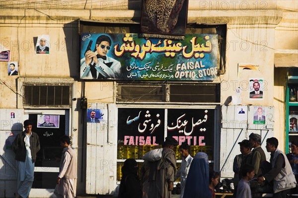 AFGHANISTAN, Kabul, "Street alongside the Kabul river, People passing infront of optic sho"