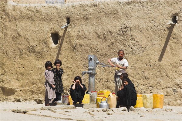 AFGHANISTAN, Ghazni, "Children fill up water containers at well near houses inside ancient walls of Citadel