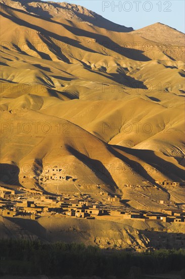 AFGHANISTAN, Bamiyan Province, Bamiyan, Late afternoon sun glows on mountains and village