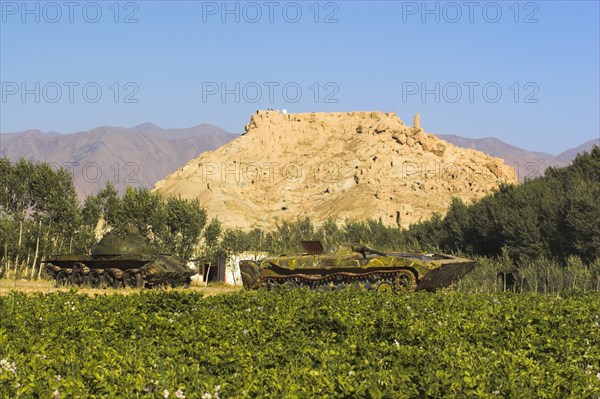 AFGHANISTAN, Bamiyan Province, Bamiyan, "Abandoned tanks in fied in front of Ruined citadel of Shahr-e-Gholgola known as City of the Screaming