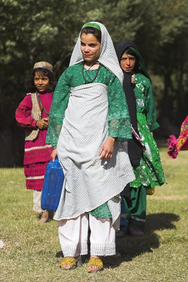 AFGHANISTAN, Ghor Province, Pal-Kotal-i-Guk, "Aimaq nomad camp, Women and girl carry containers that they filled with water from river (fetching water is usually the job of women/girls here)